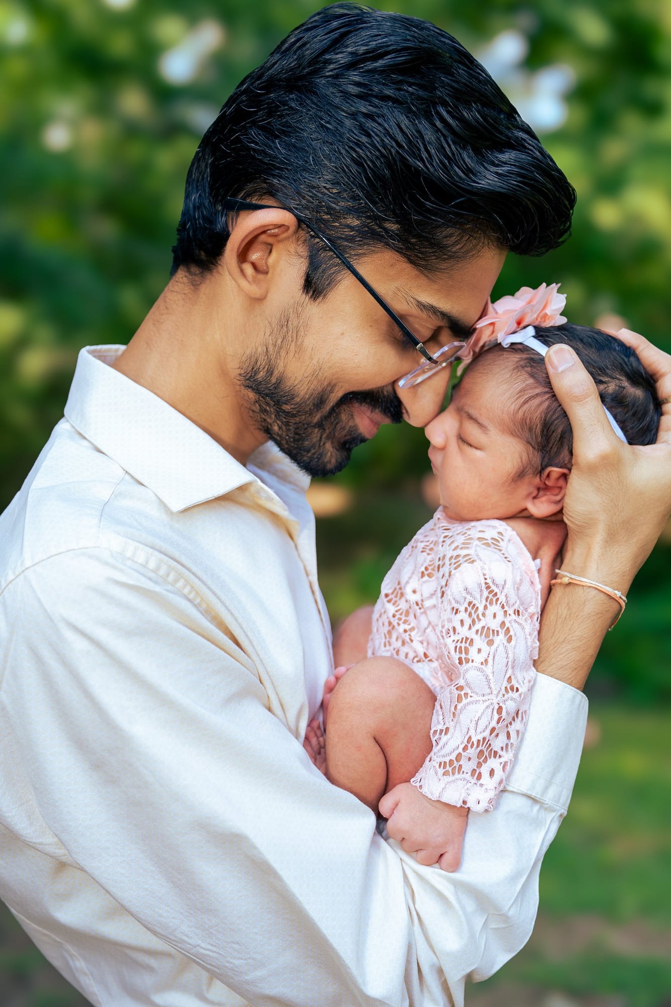 Dad kissing his newborn daughter outdoors
